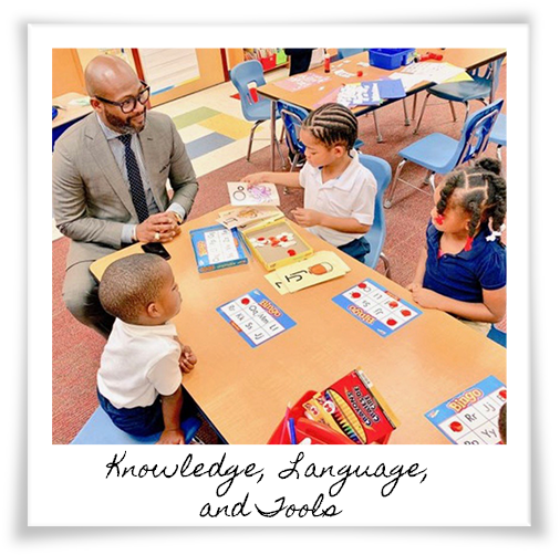 Dr. Dickey interacting with preschool learners on a table inside a classroom