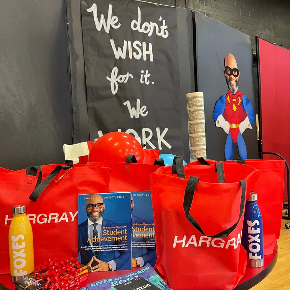 Superhero event with bags of giveaway and student achievement books
