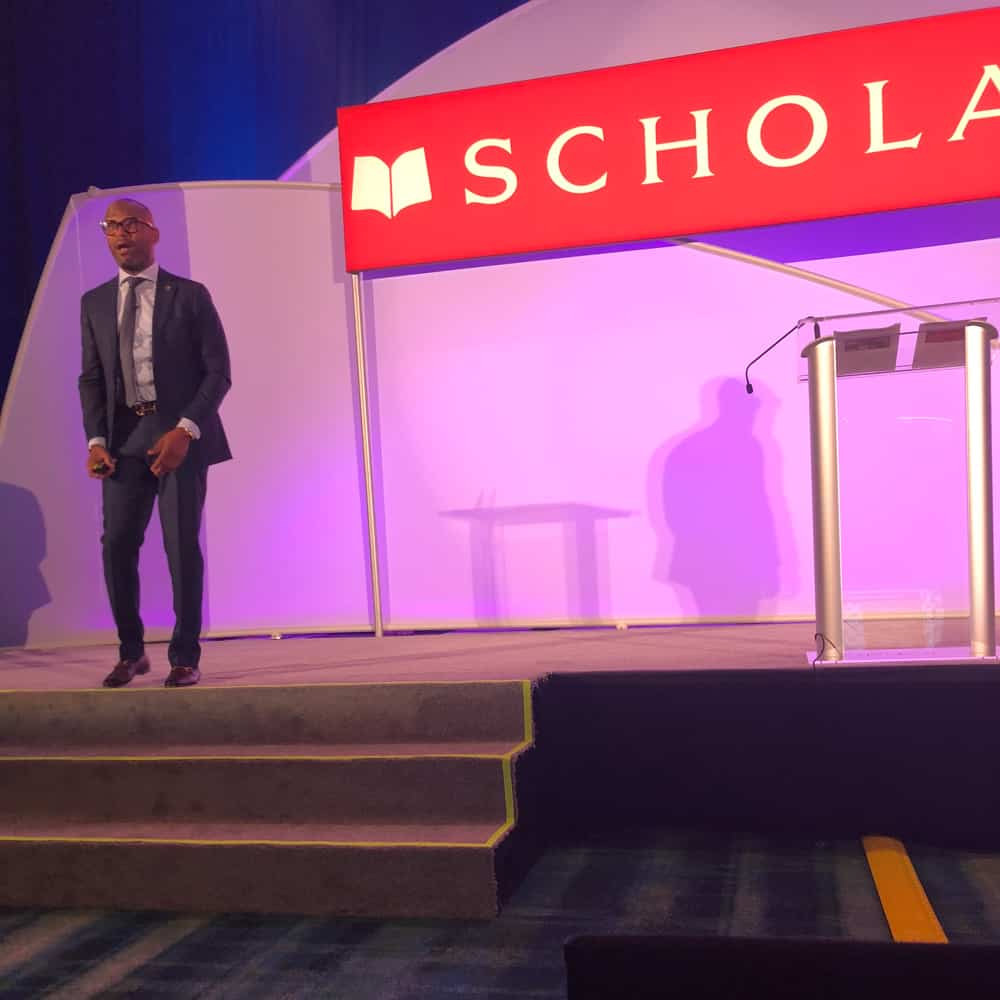 Dr. Dickey speaking on stage during scholastic event