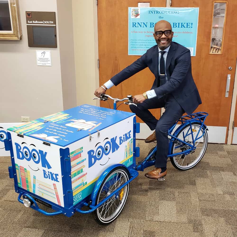 Dr. Dickey riding on a book bike